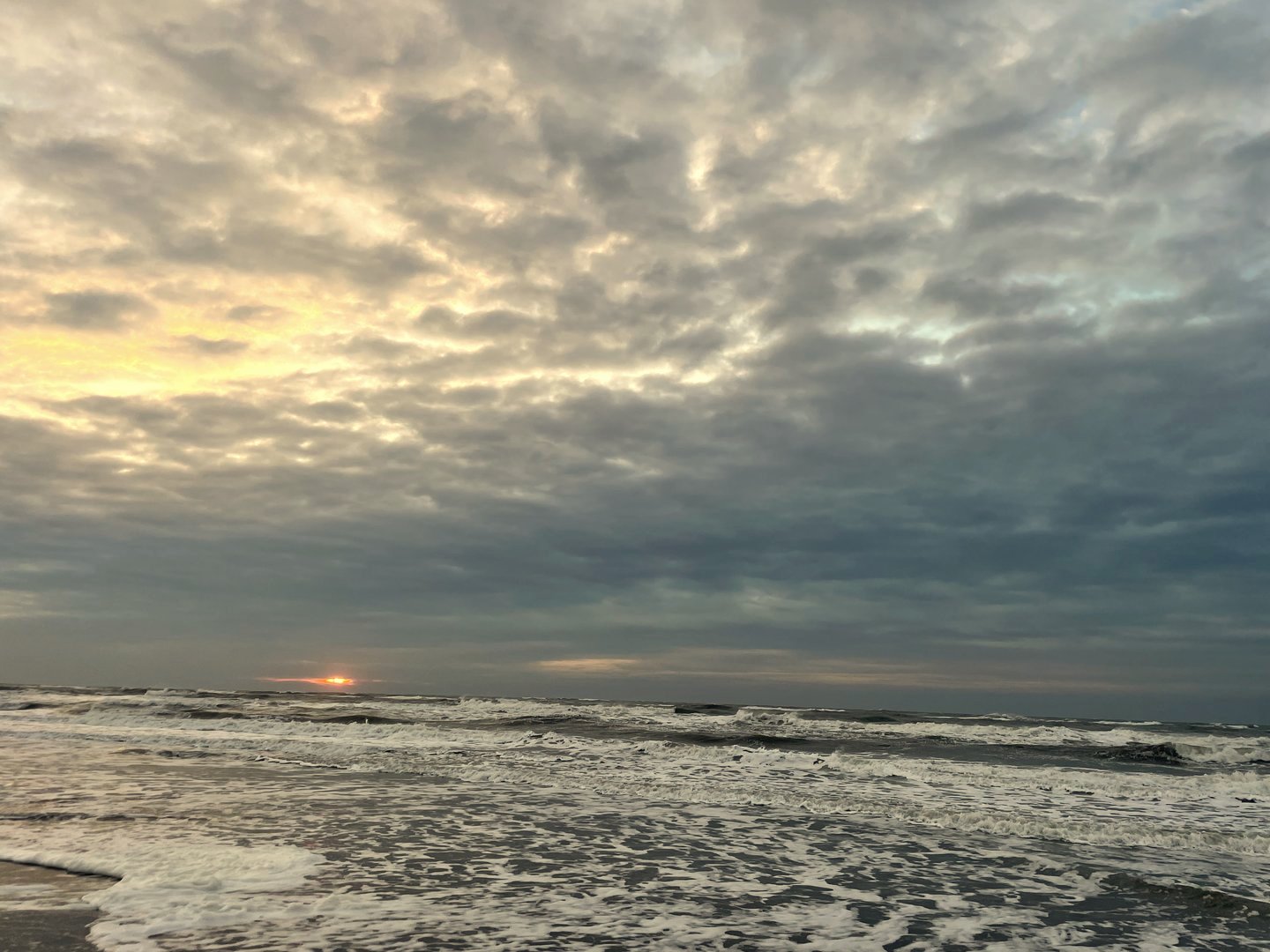 Zee met donkere wolken bij zonsondergang