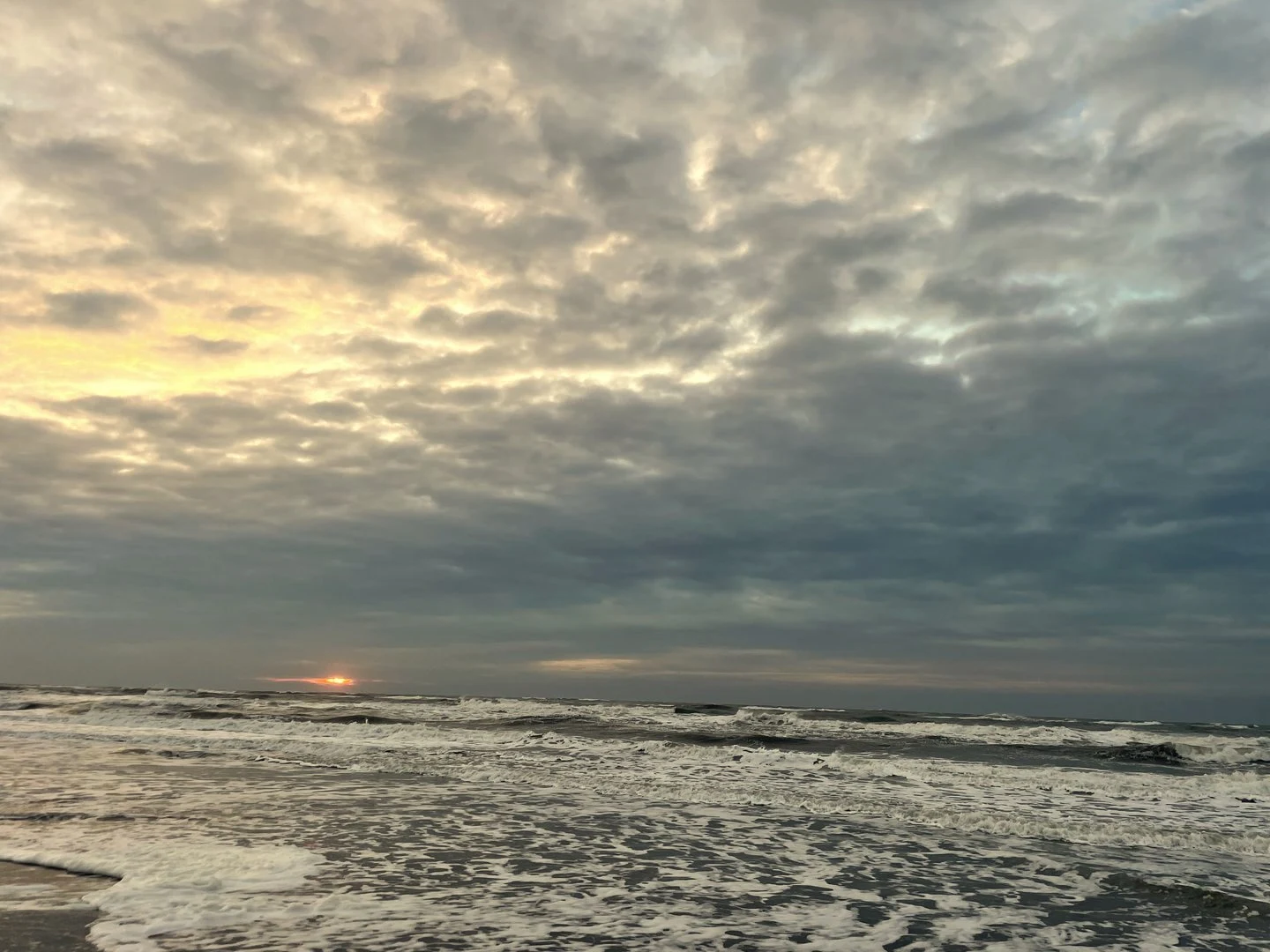 Zee met donkere wolken bij zonsondergang