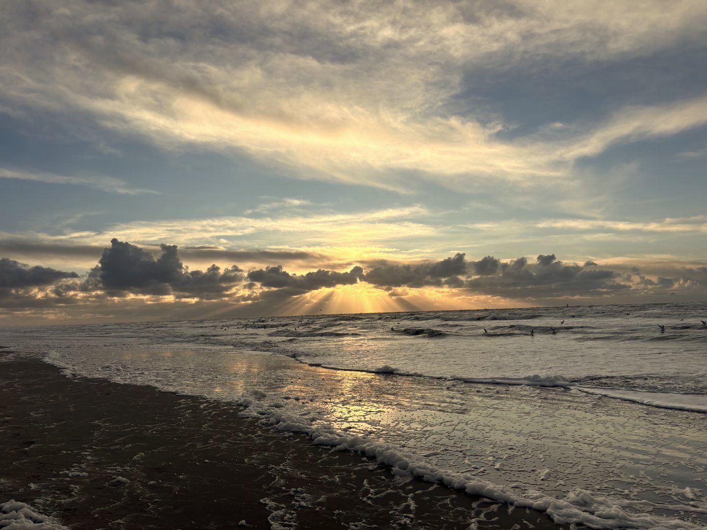 Zee bij zonsondergang met zonnestralen